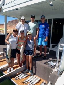 Image of a family and fishing guide on the deck of a houseboat at Lake Powell.
