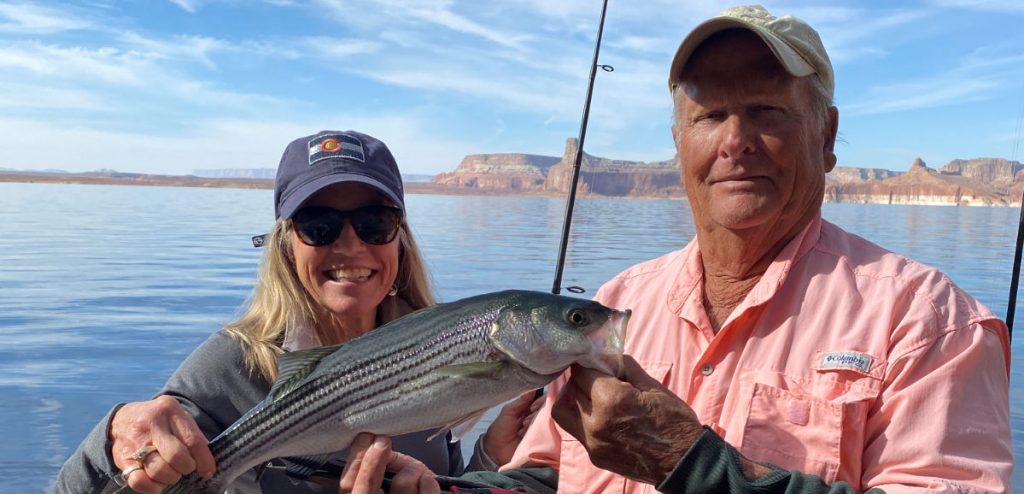 Captain Bill and guest holding a striped bass