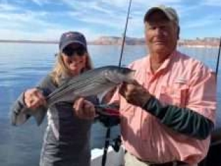 Spring Fishing starts on Lake Powell - Captain Bill McBurney and Guest holding a nice sized striper.
